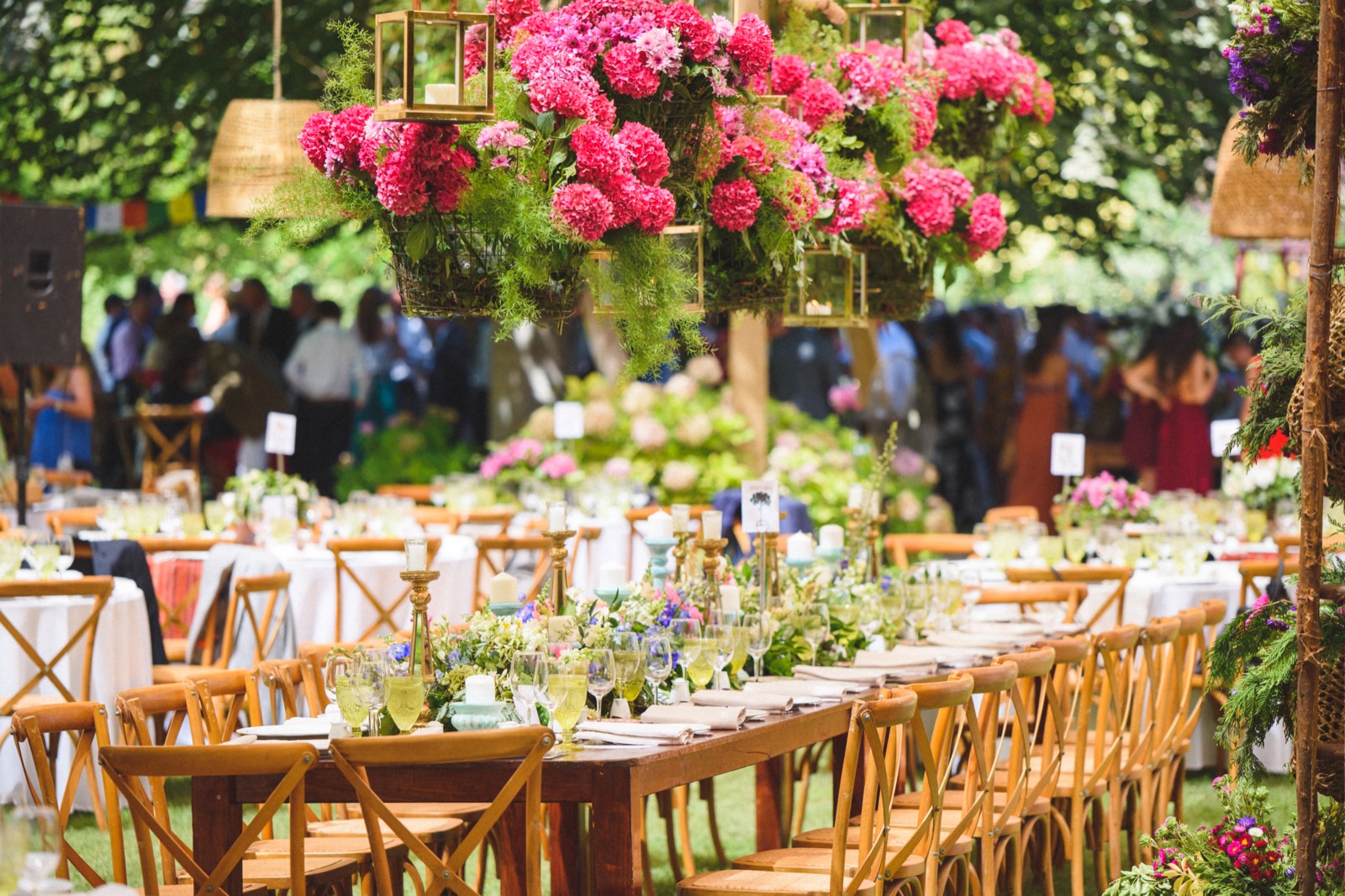 Lush outdoor wedding reception with hanging floral installations